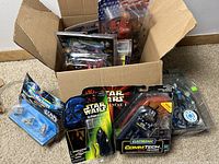 Loose box filled with vintage packaging of collectible toys including Spawn, GI Joe, and Star Wars Micro Machines and CommTech reader.