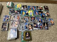 Multiple stacks of WWF Diva Collection 2001 and All Access 2002 wrestling trading cards spread out on carpet.