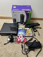Full lot showing Xbox 360 console, Kinect sensor, two controllers, game discs, power adapter, and box.