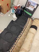 Black Brabantia carry bags with circular quick drop openings visible, lying next to rugs and other household items.