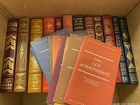 Boxed collection of twelve leather-bound volumes with gilt spines, plus multicolor paperback inserts laid in front