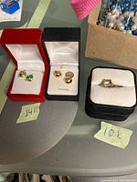 Overview of two pairs of earrings and one ring in display boxes, with sticky notes indicating "14k" and "10k"