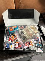Open shoe box showing hockey cards inside, including a sealed 1991 Score Young Superstars box and loose cards in plastic bags.