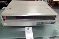 Front view of the Sony PS-FL1 record player showing the rectangular beige unit with a transparent automatic door and control buttons on the front panel.