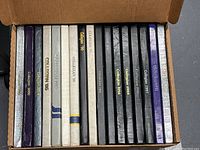 Box containing 14 Vancouver College Collegian yearbooks from 1987 to 2000 in a mix of cover colors and designs.