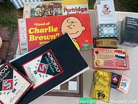 Photo showing wide view of lot games including Monopoly, Charlie Brown game, Cards Against Humanity, 5 Second Rule, Lipless, Zipt, playing cards.