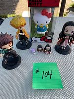 Full view of the collection with Demon Slayer main characters and Hello Kitty boxed figure plus miniature figures on display.