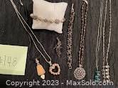 Photo of multiple sterling silver necklaces, bracelets, and earrings displayed on black fabric.