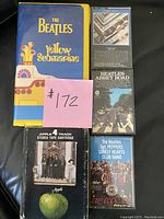 Two VHS tapes and three tape cartridges arranged on black surface