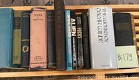 Photo showing a row of vintage hardback books including Nana by Emile Zola and The Works of Oscar Wilde.