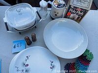 Full lot view including Corningware saucepan, flower plate, glass pitcher, salt and pepper shakers, and some other small kitchen items.