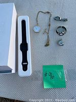 Photo of the full lot including Apple Watch Sport in box, gold pocket watch with chain, 3 wristwatches, and a small mini pocket watch.