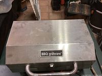 Closed view of BBQ Grillware portable barbecue grill, showing stainless steel lid and front handle