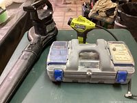 Photo showing Toro leaf blower, Ryobi air inflator, and Dremel rotary tool case on table