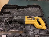 Electric reciprocating saw in carrying case, showing full saw and power cord