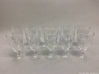 Front view of eleven Waterford Marquee crystal iced beverage goblets arranged in two rows showing clear crystal blinds and faceted stems.