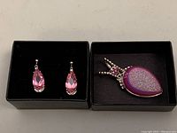 Boxes with earrings and pendant showing pink teardrop crystals and silver setting