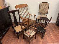 Five assorted antique chairs grouped together showing differences in design, upholstery, and condition.