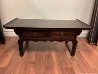 Front view of the dark wooden low altar table showing two drawers with ring handles and carved leg details.