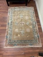 Full view of the carpet showing overall condition and design including floral border and central medallions.