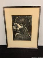 Front view of framed ink and wash painting of a profile portrait with mat and wood frame.