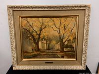Framed Robert Wood print showing full view of autumn street scene with person and houses, ornate frame with gold finish