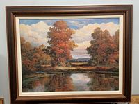 Full framed artwork showing autumn landscape with pond and trees under cloudy sky