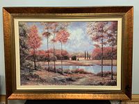 Framed textured print on canvas showing the full artwork and frame with a landscape scene featuring trees and water.