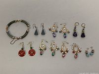 Full view of the bracelet and the 6 pairs of earrings laid out.