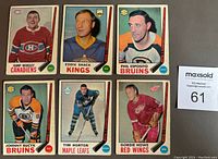 Photo of 6 cards including Gump Worsley Canadiens, Eddie Shack Kings, Phil Esposito Bruins, Johnny Bucyk Bruins, Tim Horton Maple Leafs, Gordie Howe Red Wings.