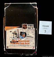 Worn outer cardboard box with NHL Pro Set graphics and promotional text, showing wear on edges and corners.