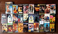 Top-down view of 30 VHS videotape covers arranged in rows showing a wide variety of classic films and titles