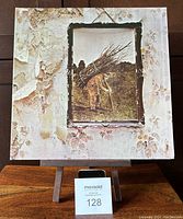 Front album cover of Led Zeppelin IV showing iconic artwork of man carrying sticks and peeling wallpaper design.
