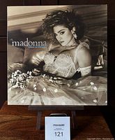 Front cover of Madonna Like a Virgin vinyl album showing Madonna in lace bustier, tulle skirt against satin pillow backdrop.