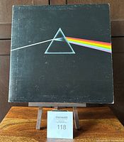 Front view of the Pink Floyd Dark Side of the Moon gatefold album cover with iconic prism design showing wear and handling marks on black background.