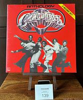 Front cover of The Commodores 'Anthology' double vinyl LP showing band members and logo on red background with 2-record set label.