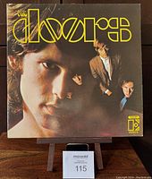 Front cover of The Doors first album vinyl LP showing Jim Morrison and band members with yellow logo.