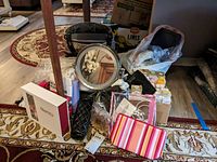 Wide view of all items including mirror, cases, boxed items, cosmetic bag, hair care products and caps