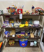 Four shelves filled with various small vintage collectibles, toys, buttons, and household items.