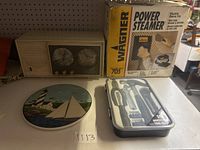 Vintage clock radio, Wagner Power Steamer box, decorative plate, and 14-piece household tool kit all shown together