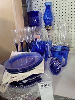 Front view showing all cobalt blue glassware, clear stemware glasses, and lamps
