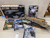 Overview of Star Trek model kit box, Battlestar Galactica ship model on original game box, and four Star Trek action figures in packaging.