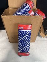 Open cardboard box with multiple unopened packs of Americana steel wool pads labeled Grade 1 Medium.