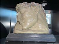 Side profile view of composite bust sculpture showing left profile and laurel wreath detail.