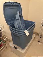 Large blue plastic storage container with its lid open showing inside