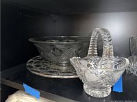 Glass serving platter, decorative bowl, and candy dish basket displayed together on shelf. Shows size and etching of all items.