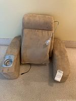 Wide view of beige fabric backrest massager with padded arms, control panel and cup holder on right arm, and power cable attached.