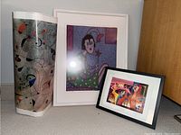 Photo showing all three items together: two framed prints signed and numbered by Debra Lawrence and one rolled unframed print