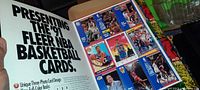 Photo showing an open page of a 1991 Fleer NBA basketball card promotional sheet with multiple cards visible and text about the product.