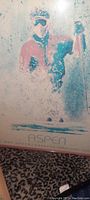 Framed vintage skiing print by Dan Young depicting a skier in winter scene.